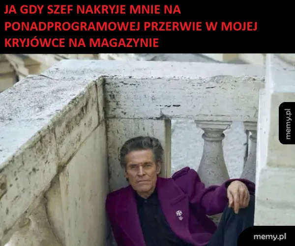 Mężczyzna w fioletowym garniturze siedzi w kącie na schodach.
