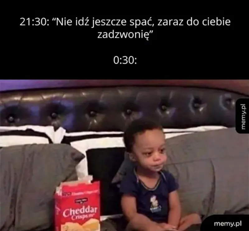 Mały chłopiec siedzi na łóżku z zdezorientowanym wyrazem twarzy, obok paczka chipsów.