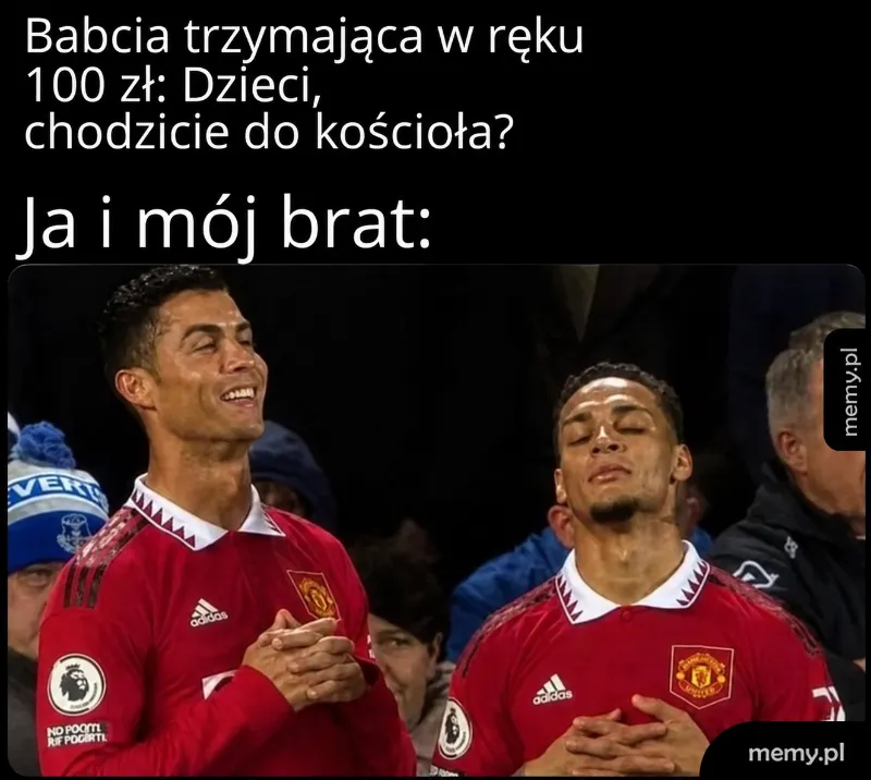 Dwaj piłkarze w czerwonych strojach, jeden z zamkniętymi oczami, drugi z uśmiechem.