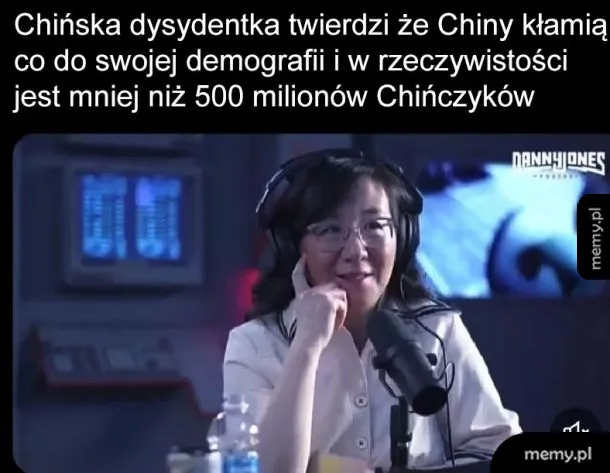 Kobieta w słuchawkach siedzi przy mikrofonie, w tle ekrany komputerów.
