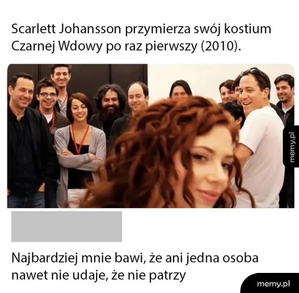 Scarlett Johansson w kostiumie Czarnej Wdowy, grupa ludzi w tle.