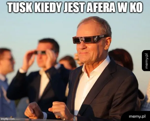 Mężczyzna w okularach przeciwsłonecznych na tle grupy ludzi.