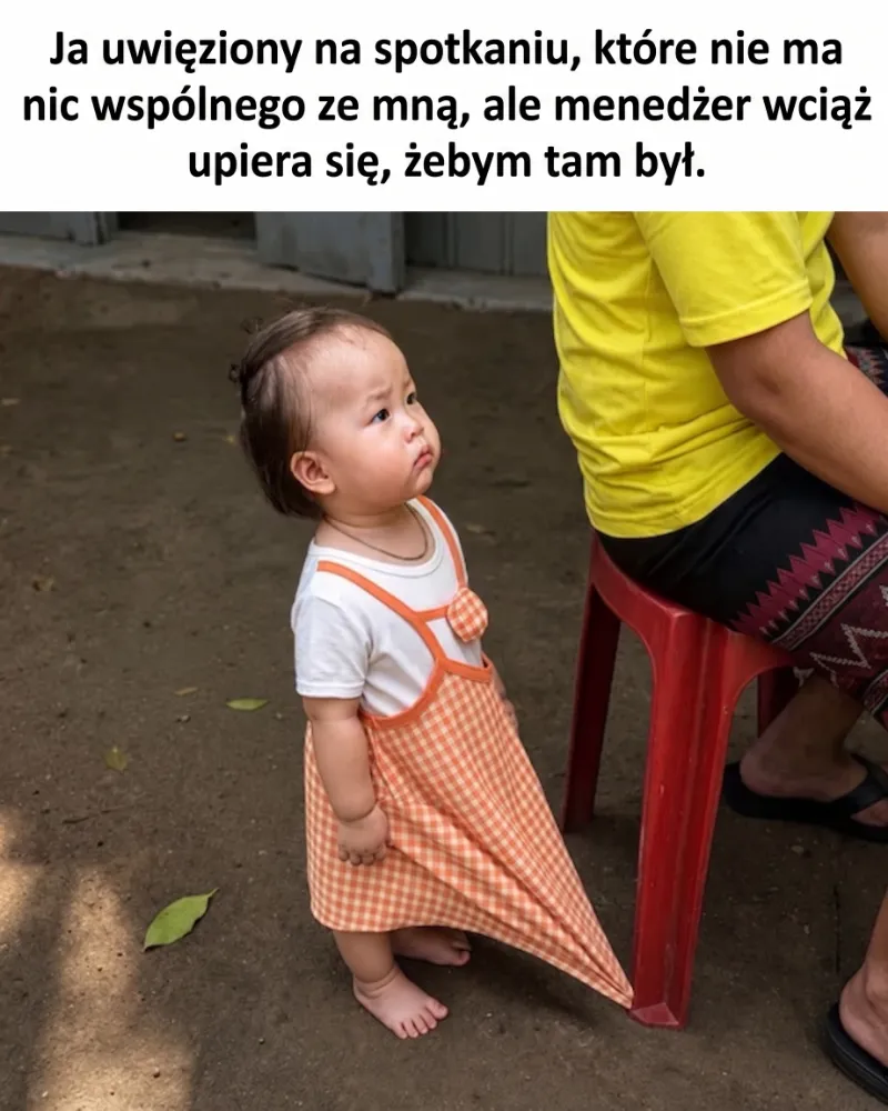 Małe dziecko w pomarańczowej sukience stoi obok osoby siedzącej na krześle.