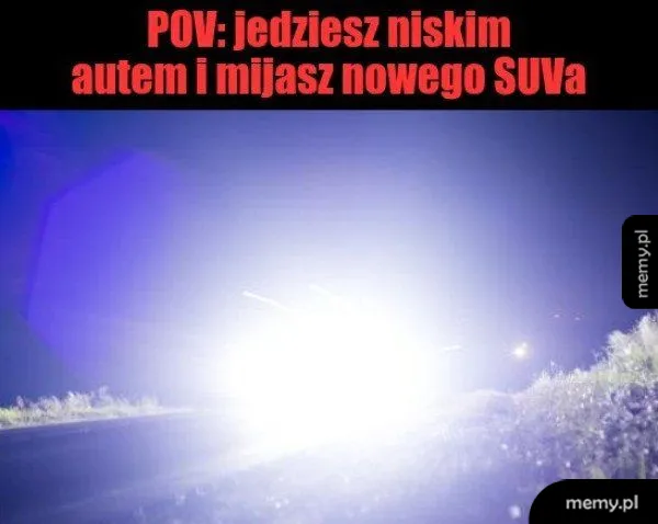 Oślepiające światła samochodu na drodze w nocy