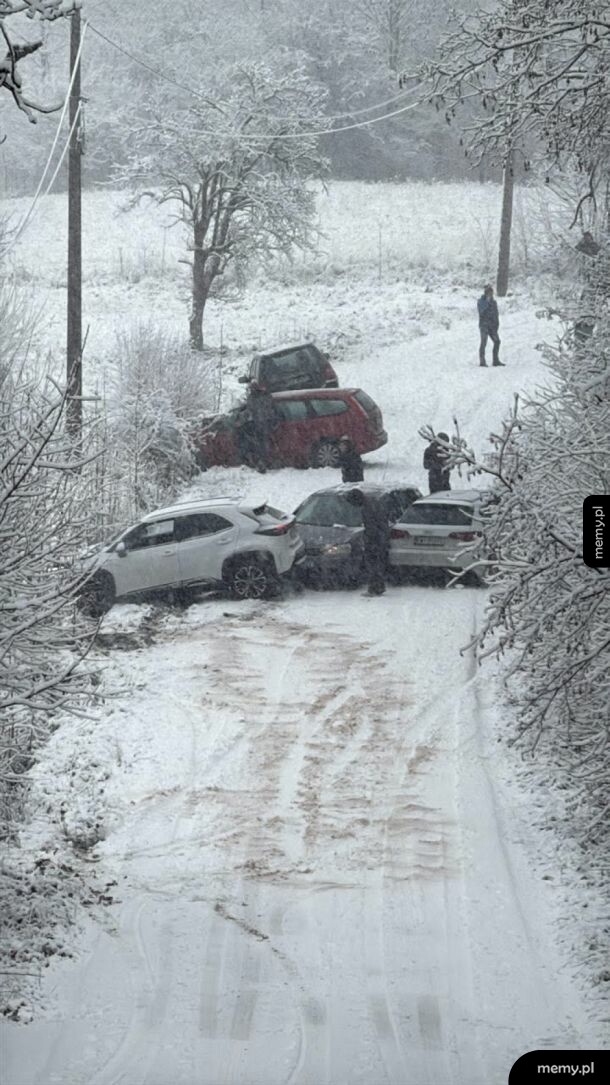 Karambol kilku samochodów na oblodzonej, zaśnieżonej drodze.